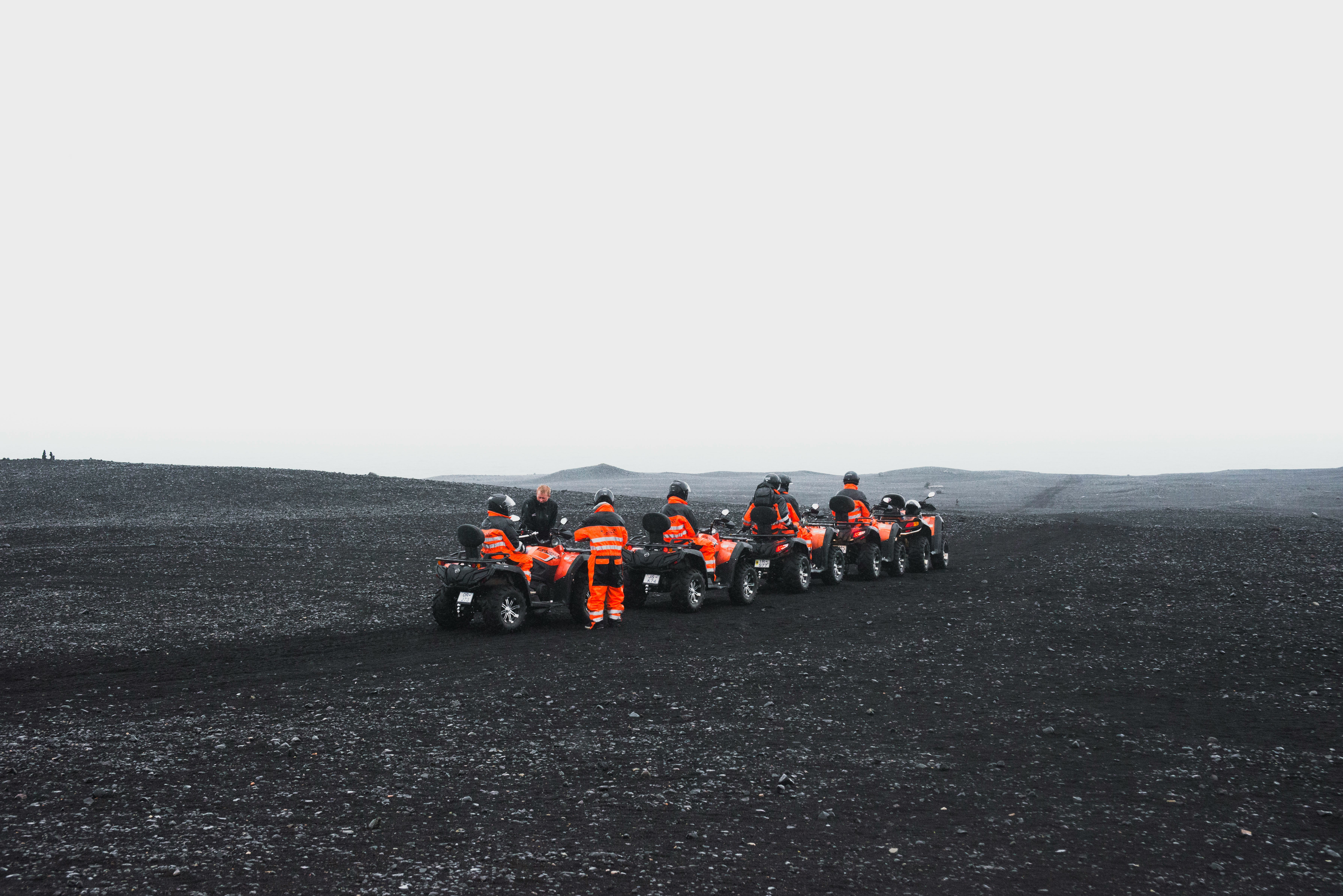group of people in orange suit riding a ATV